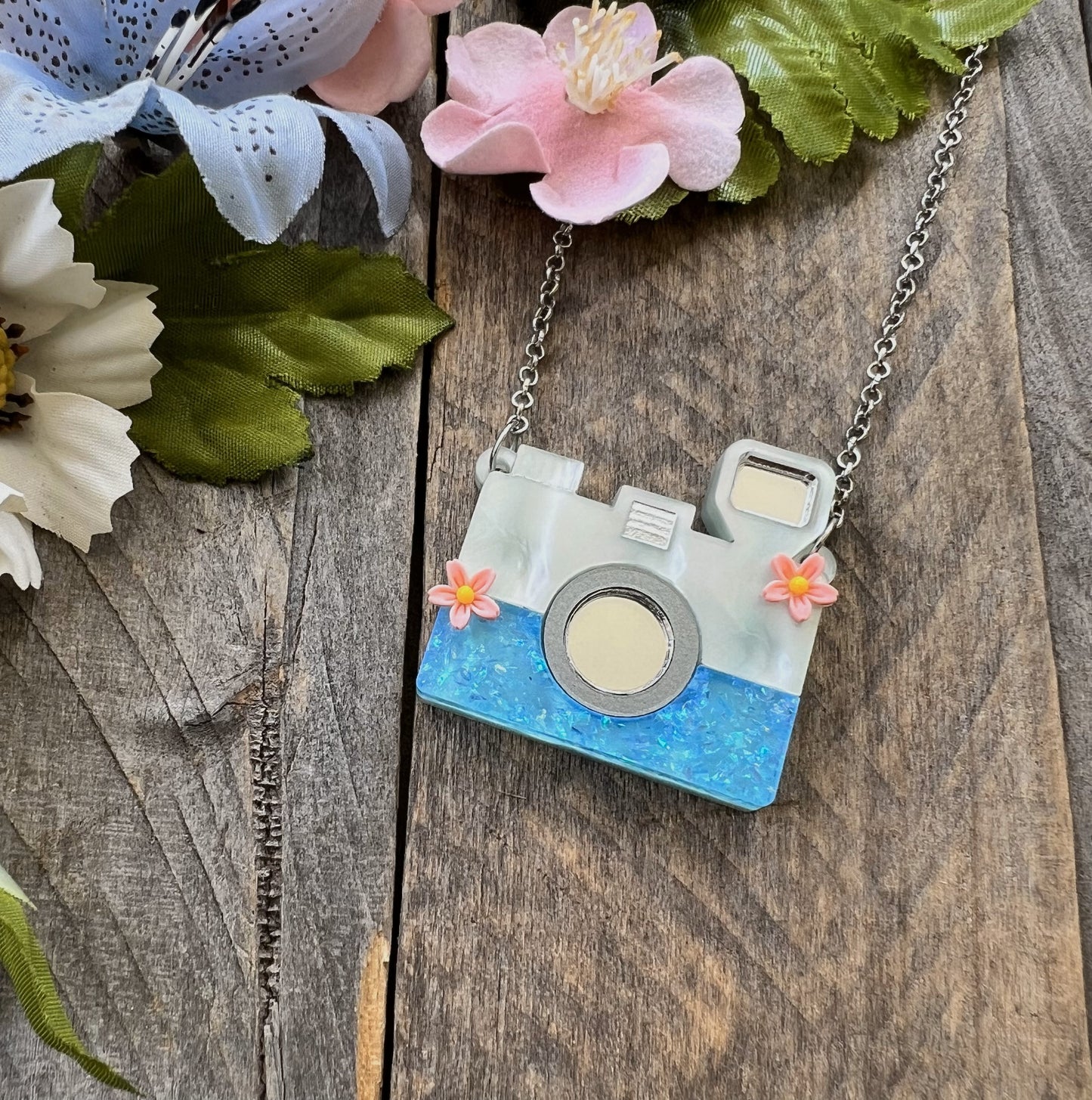Camera necklace on wood background