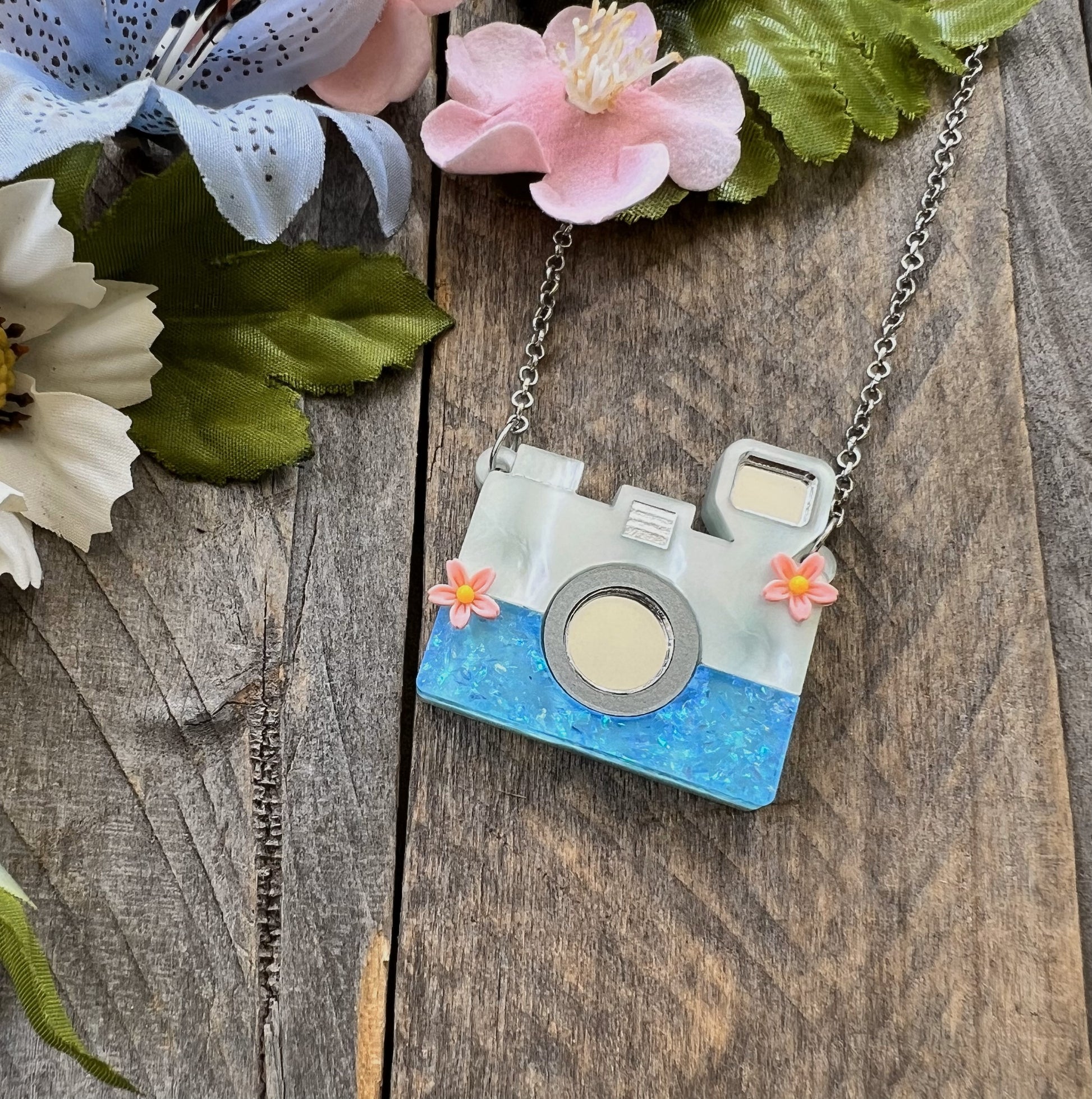 Camera necklace on wood background